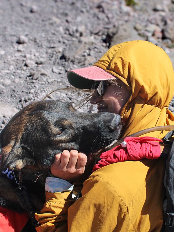 Photograph of young woman and a german shepherd dog embracing
