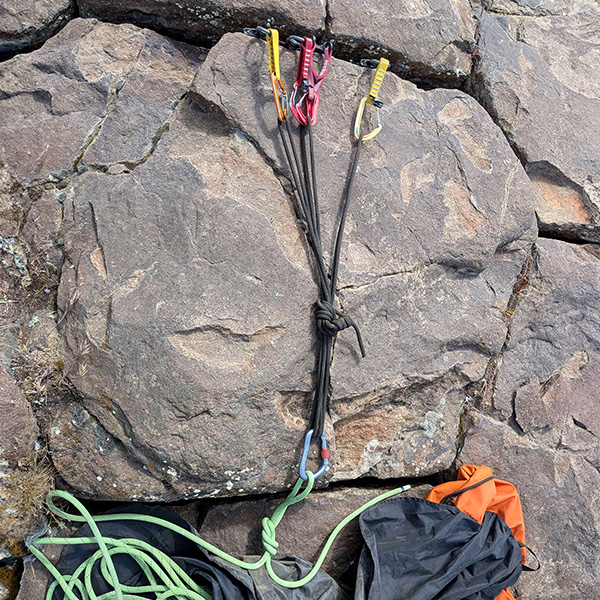 Traditional climbing gear anchor with a single line descending from it