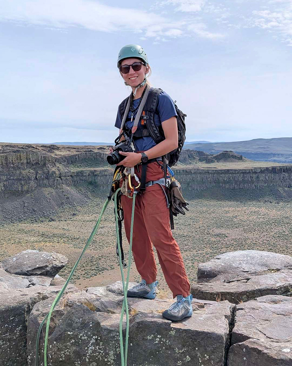 Rock climbing photographer rigged for rappeling and ascending