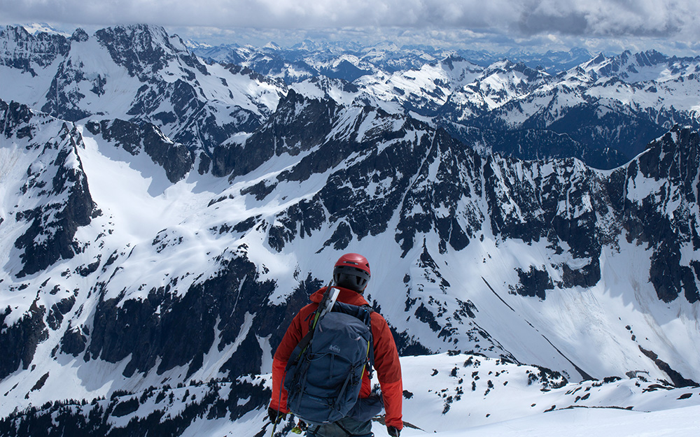 Male mountaineer in red facing the North Cascades