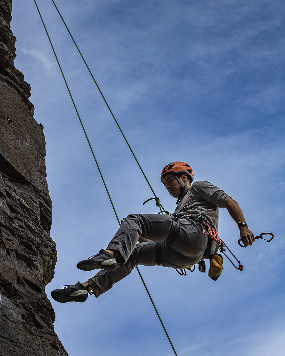 Rock climber coming down after a successful lead climb