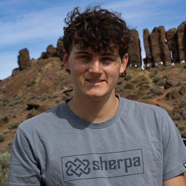 A young man faces the camera smiling